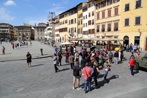 Tourists on the Piazza di Santa Croce plaza surrounded by historical buildings in Florence, Italy on September 23, 2017