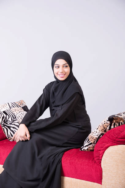 istock Arab beautiful woman sitting on sofa at home 889555380