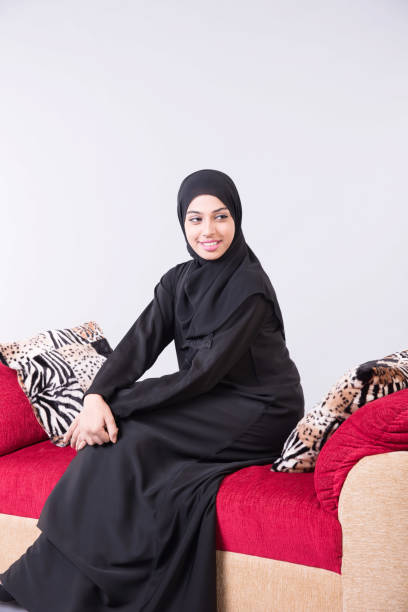 istock Arab beautiful woman sitting on sofa at home 889555454