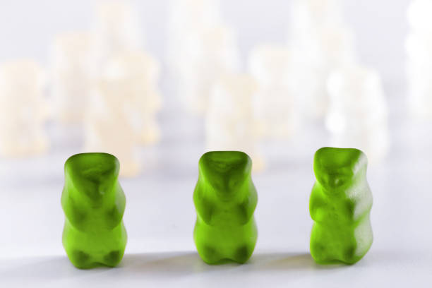 istock Colored gummy bear candy standing out from the crowd arrangement close-up studio shot 889563014