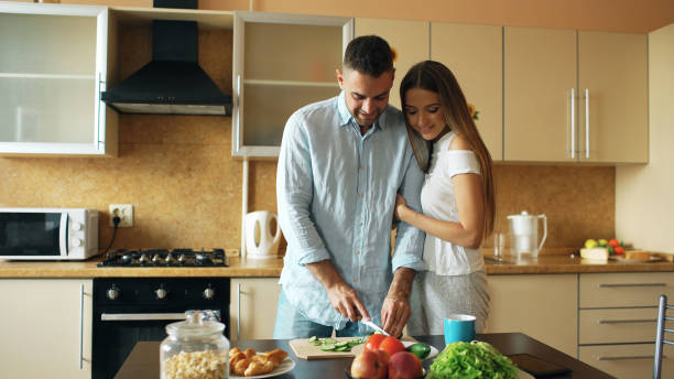 istock Happy young couple in the kitchen. Handsome man meet his girlfriend early morning 889565708