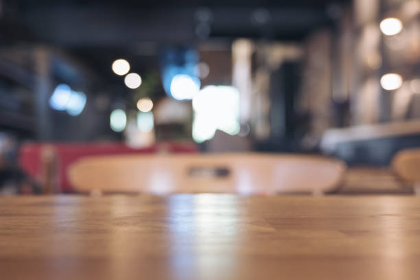 istock Wooden table and chairs in modern loft cafe with blur bokeh vintage background 889574204
