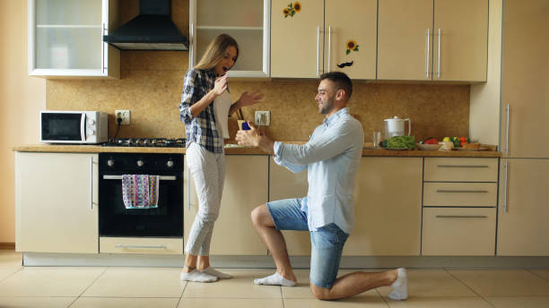 istock Young man making proposal to his girlfriend in the kitchen at home 889577336