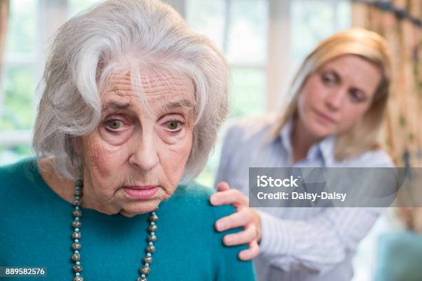 Photo libre de droit de Femme Senior Confondue Avec Fille Adulte À La Maison banque d'images et plus d'images libres de droit de Troisième âge