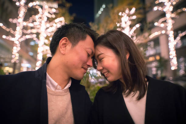istock Happy couple touching forehead each other in Christmas lights 889587158