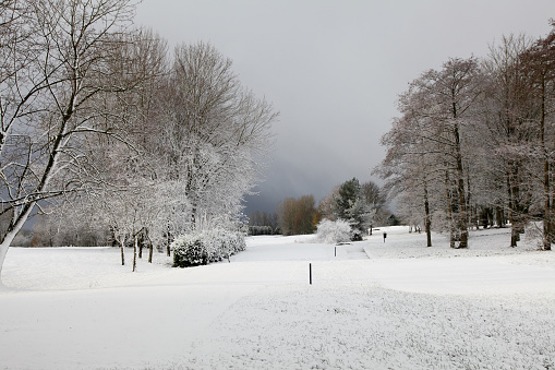 Golf course in winter with snow and dark clouds