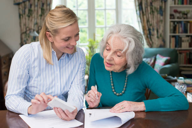 istock Woman Helping Senior Neighbor With Paperwork 889592690