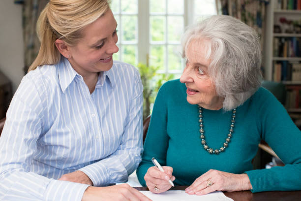 istock Woman Helping Senior Neighbor With Paperwork 889592786