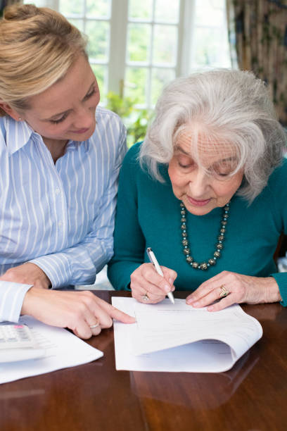 istock Woman Helping Senior Neighbor With Paperwork 889592898