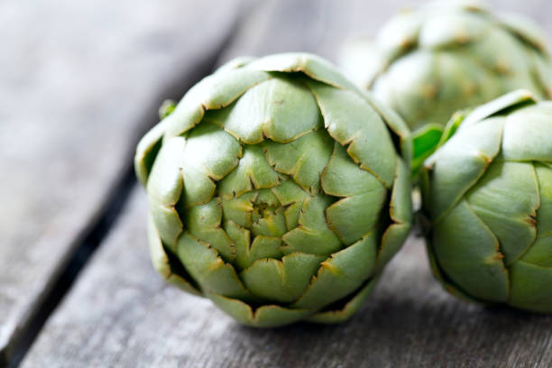 istock artichokes on wooden surface 889605786