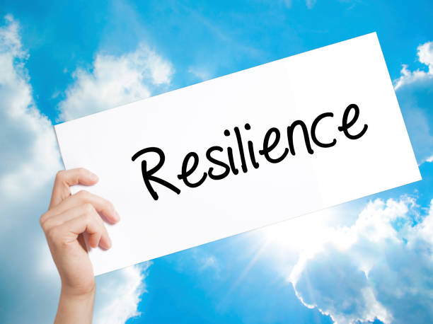 resilience sign on white paper. man hand holding paper with text. isolated on sky background - energia reativa imagens e fotografias de stock