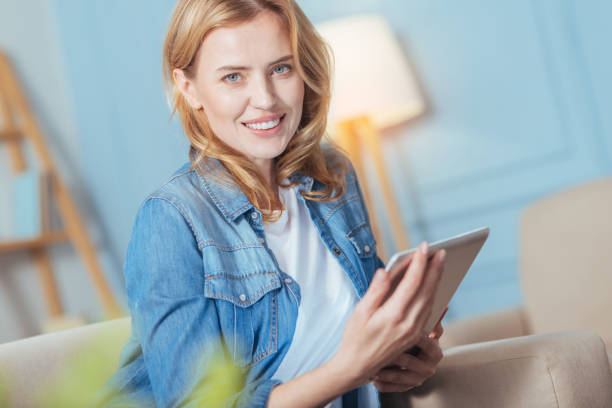 istock Pretty smiling woman relaxing while sitting at home with her tablet 889609400