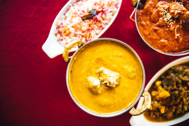 istock Butter chicken, lamb curry, vegetable curry and basmati rice on a table. North Indian food 889609430
