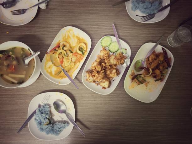 istock Assorted Thai food set. Stir-Fried Chicken with Cashew Nuts, Stir fried squid with salted egg, hot and spicy pork rib with Thai herbs on the table, vintage tone & still life style. Top view 889609626