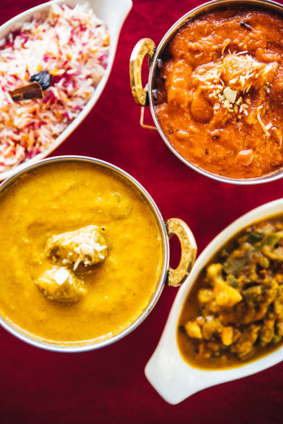 istock Butter chicken, lamb curry, vegetable curry and basmati rice on a table. North Indian food 889609878