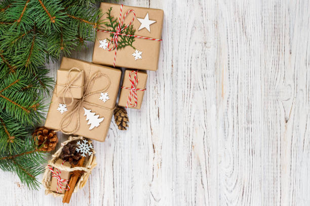 istock Christmas gift boxes and fir tree branch with basket on wooden table 889610056