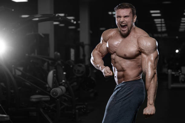 istock Brutal strong bodybuilder athletic men pumping up muscles with dumbbells 889614940