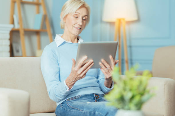 istock Progressive senior woman watching a video while looking at the tablet 889615060