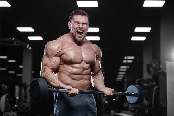 istock Brutal strong bodybuilder athletic men pumping up muscles with dumbbells 889615130