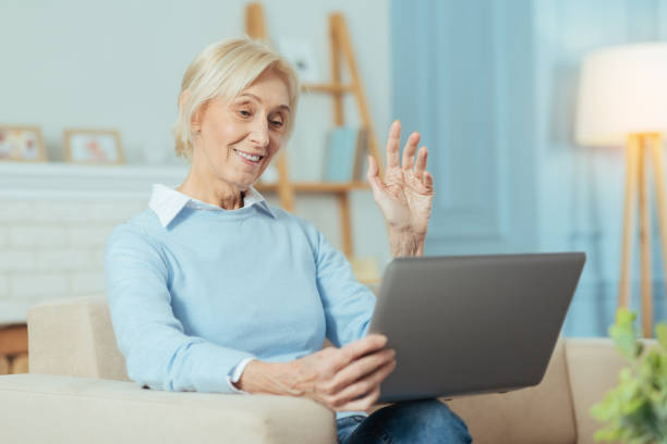 istock Smart senior woman smiling while having a video call with her grandchildren 889616664