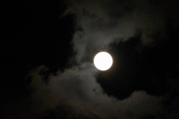 istock Full moon with fluffy clouds in the sky 889617602