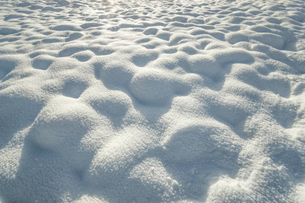 fresco sfondo di superficie di neve collinare e fiocchi di neve alla deriva. neve accidentata che copre il paesaggio invernale. - deep of field foto e immagini stock