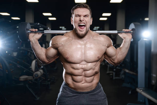 istock Brutal strong bodybuilder athletic men pumping up muscles with dumbbells 889619112