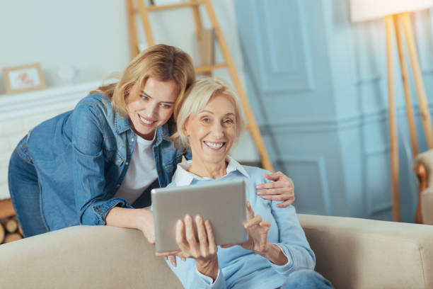 istock Positive pensioner laughing while her granddaughter standing by her side 889621160