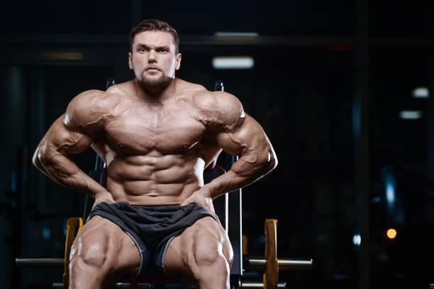 istock Brutal strong bodybuilder athletic men pumping up muscles with dumbbells 889626686