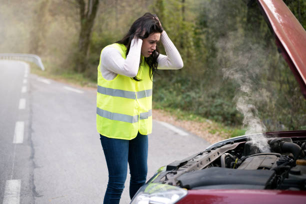 istock Panicked woman looks at smoking car 889627342