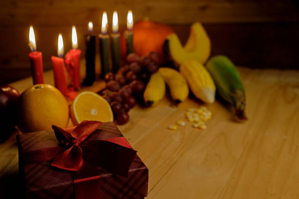 Kwanzaa holiday concept with decorate seven candles red, black and green, gift box, pumpkin,corn and fruit on wooden desk and background. Kwanzaa holiday concept with decorate seven candles red, black and green, gift box, pumpkin,corn and fruit on wooden desk and background. kwanzaa stock pictures, royalty-free photos & images