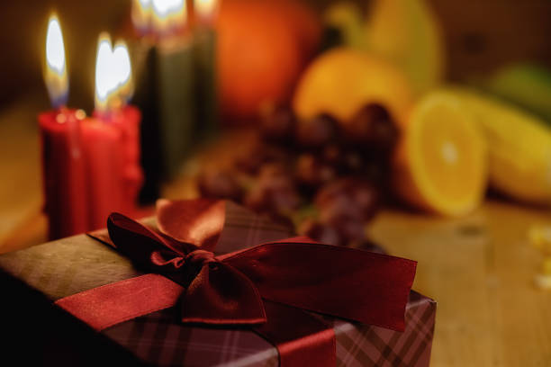 Kwanzaa holiday concept with decorate seven candles red, black and green, gift box, pumpkin,corn and fruit on wooden desk and background. Kwanzaa holiday concept with decorate seven candles red, black and green, gift box, pumpkin,corn and fruit on wooden desk and background. kwanzaa stock pictures, royalty-free photos & images