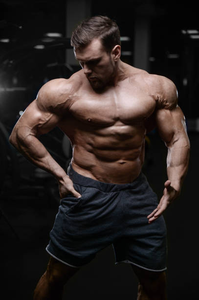 istock Brutal strong bodybuilder athletic men pumping up muscles with dumbbells 889630802
