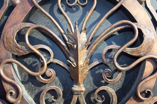 Grey metal lily hanging on the door. Handmade metal flower forged hanging on the wall of blacksmith workshop studio. Ornament for metal door.