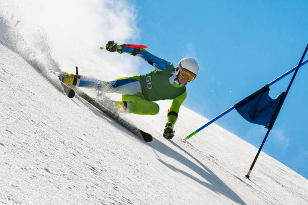 青空に巨大なスラローム レースでプロのアルペン スキーヤー compeeting - compeeting ストックフォトと画像