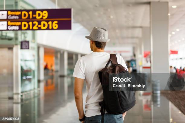 The Man In The Hat In The Airport Business Travel Passenger Looking At Timetable Screen Board Stock Photo - Download Image Now