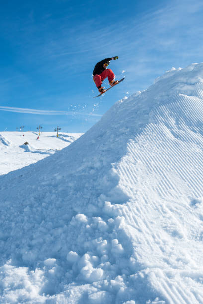 istock Snowboarder jumping against blue sky 889654444