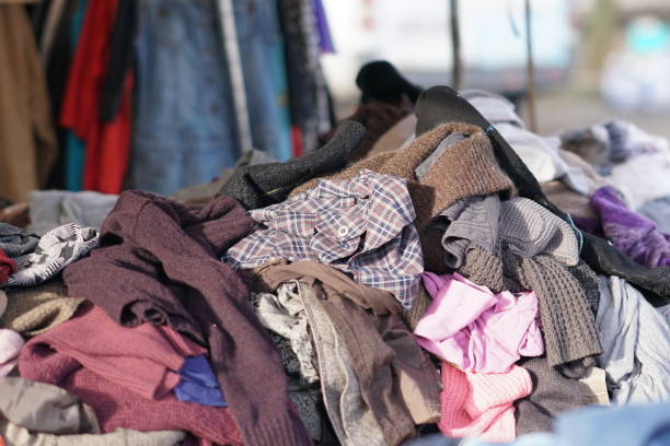 istock Heaps of clothing on second hand market 889658378