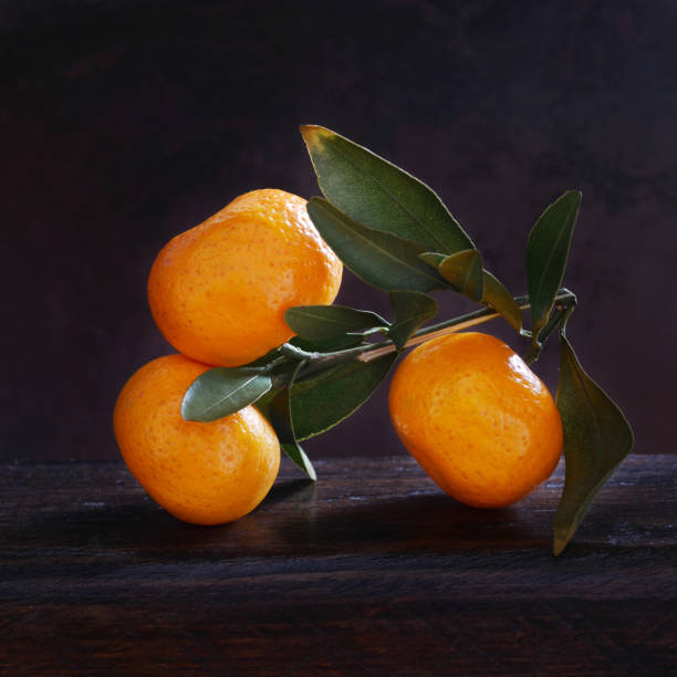 istock Mandarins with leaves on a dark wooden background. 889700198