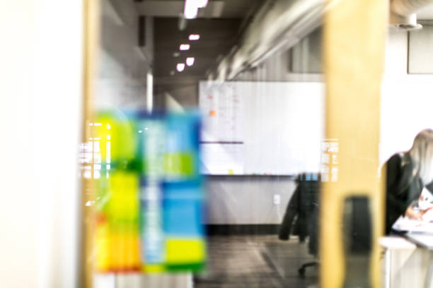 istock Businesswoman inside a modern office. Door ajar 889700576