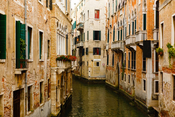 narrow canals are famous and typical in venice. - venice italy gondola gondolier sunset imagens e fotografias de stock