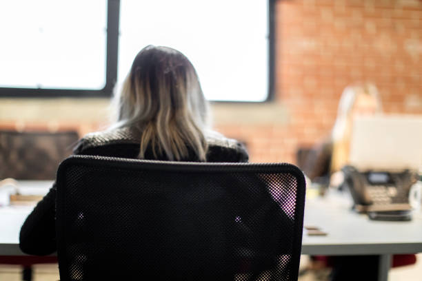 istock Young businesswomen sitting at a desk and using a laptop. Office worker. Concentration, focus. Millennials. Women working together. 889703286