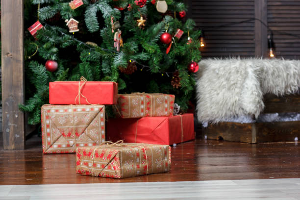 istock Red gift boxes near the christmas tree during christmas celebration. 889703826