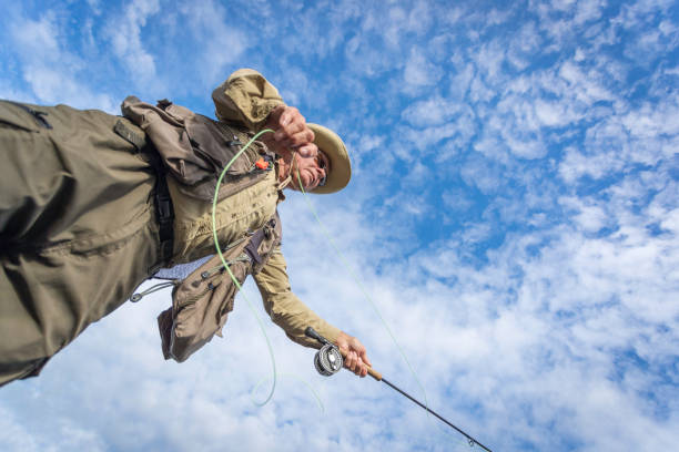 pov старший человек рыбак fly рыбалка в реке - bass angling стоковые фото и изображения