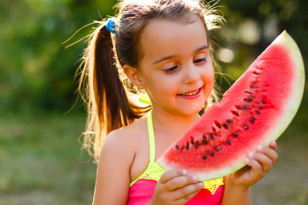 istock Small girl eating watermelons on lawn 889715640