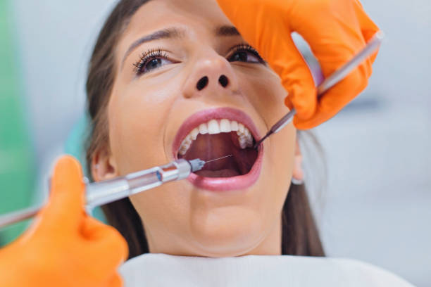 Dentist giving anesthesia to the patient Dentist holding a syringe and prepering to anesthetizing female patient dental syringe stock pictures, royalty-free photos & images