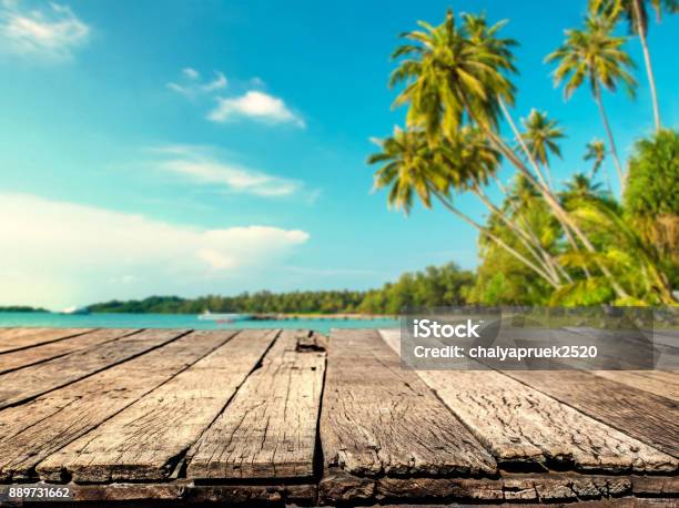 Photo libre de droit de Table En Bois Avec Fond Arbre Flou Mer Et Noix De Coco banque d'images et plus d'images libres de droit de Plage