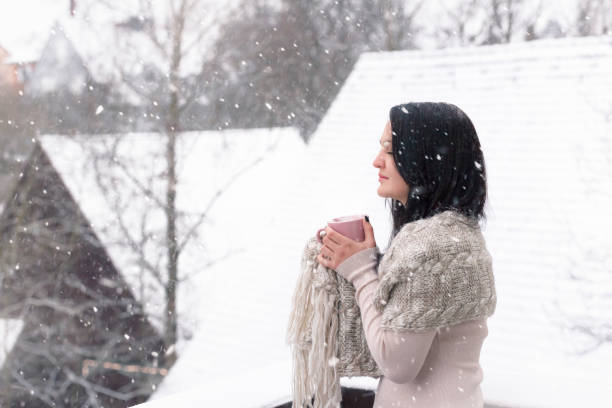 istock Woman with hot drink under snowfall 889763388