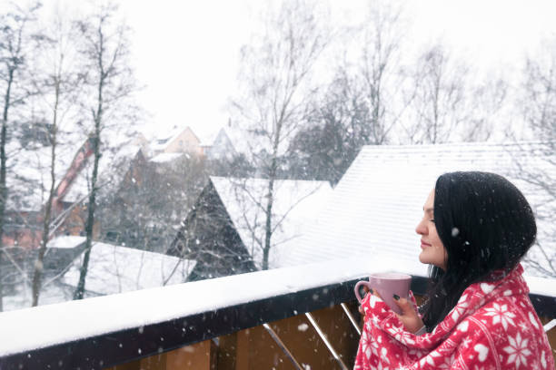 istock Woman with drink and blanket under snowfall 889763406