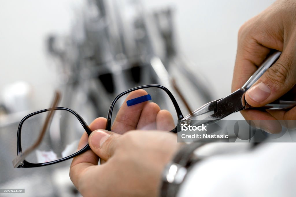 Optician repairing eye glasses Optician repairing and fixing eye glasses Eyeglasses Stock Photo